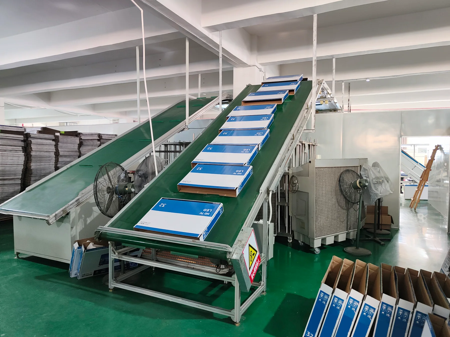 Packaging cartons moving along an inclined factory conveyor